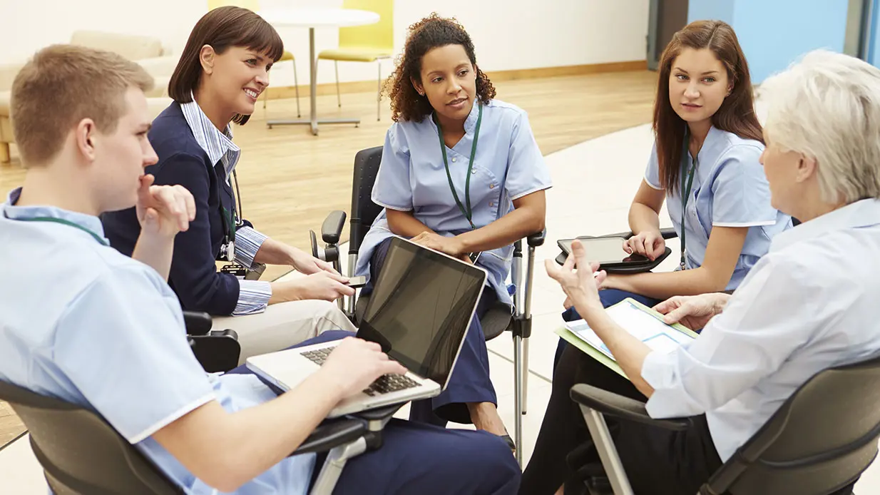 Caregivers having a discussion about infection prevention.