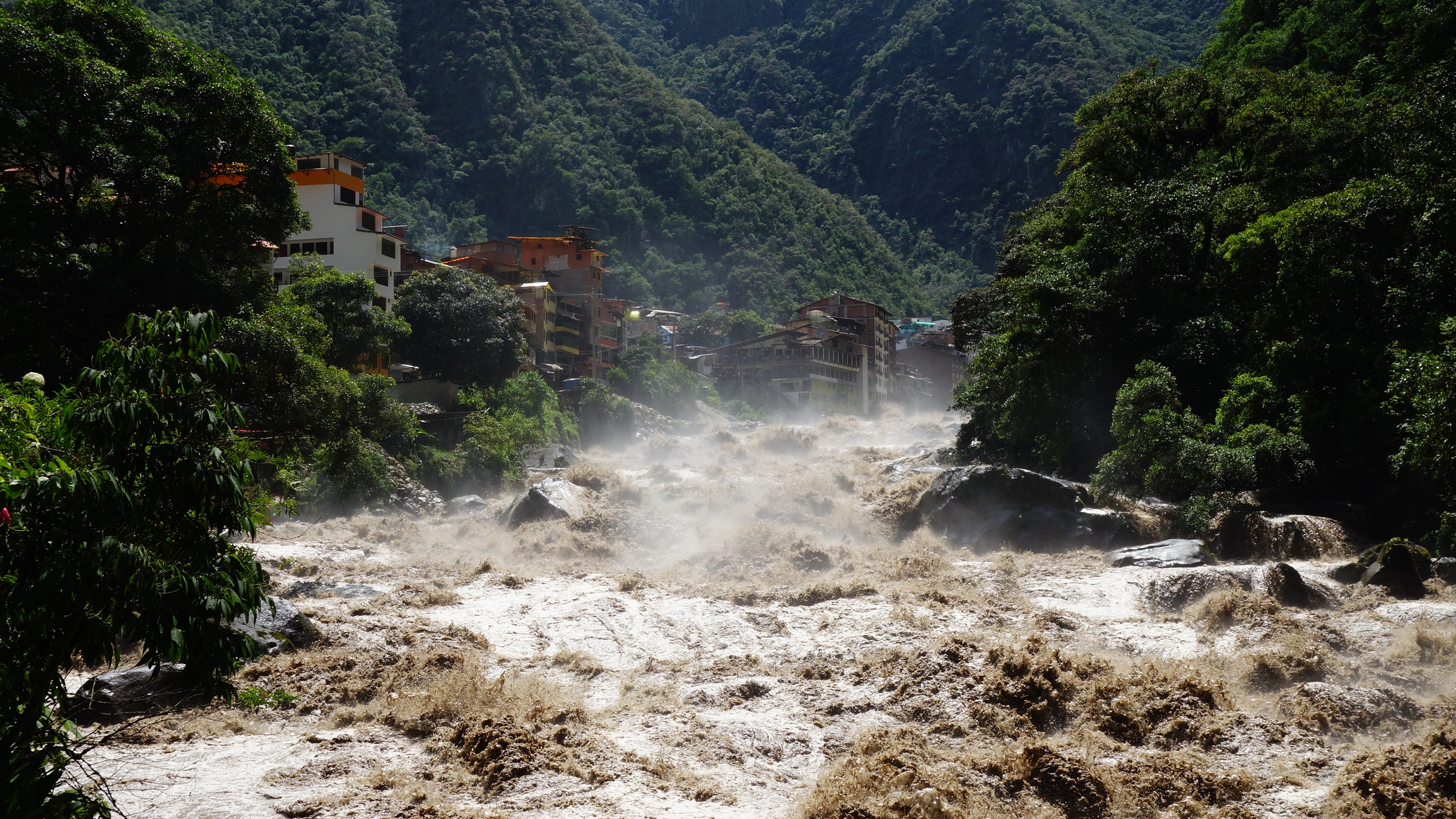 Peru floods: Fast-flowing, muddy water surges through a town, highlighting the urgent need for safe water.